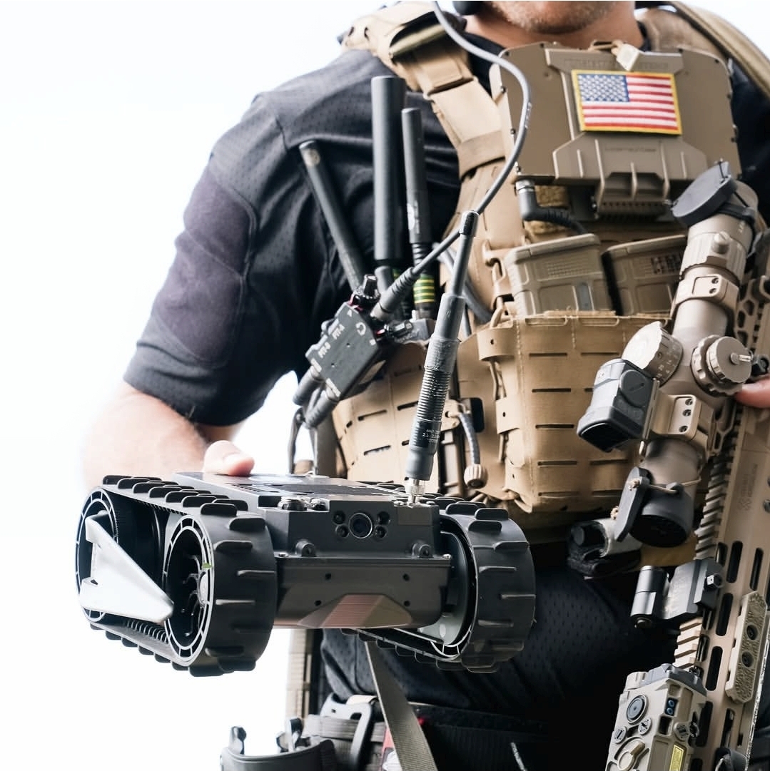 UGV portátil sobre esteiras acoplado ao operador em plate carrier